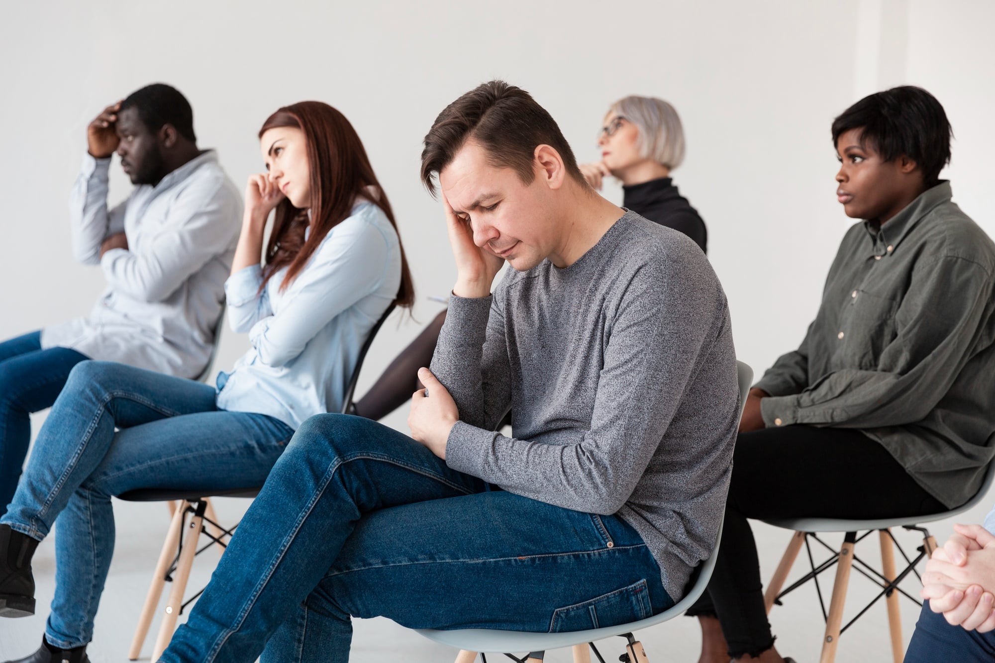 A group of patients discussing mental health medication Massachusetts during therapy.