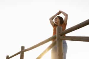 Low angle of smiley woman posing outdoors in nature, psycotherapy massachusetts