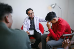 A man tapping another man’s shoulder during a consultation