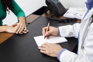 a doctor writing prescription for patient, anxiety management massachusetts
