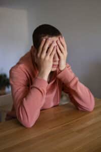 a boy with his hands on his face, ocd and trauma related conditions in massachusetts