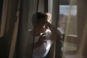 man with curtains and shadows from window looking depressed, psychopharmacology online massachusetts