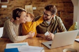 happy-daughter-embracing-kissing-her-working-parents-home