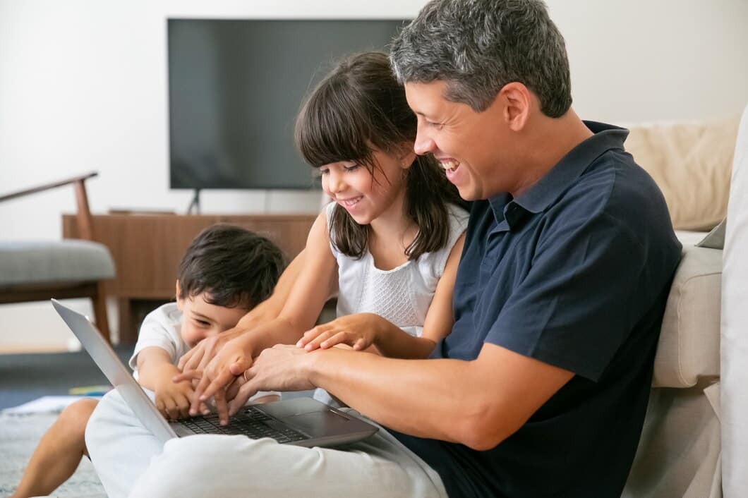 joyful-happy-dad-two-kids-using-laptop-together-sitting-floor-apartment-pressing-buttons-keyboards