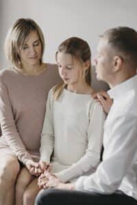 a mother and daughter holding onto their daughter, family therapy in massachusetts