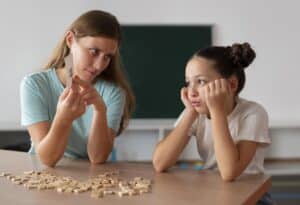 Psychologist helping a girl in speech therapy, massachusetts adhd