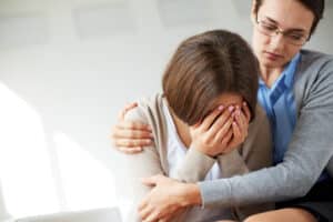 Image of compassionate psychiatrist comforting her crying patient, ptsd and trauma care massachusetts