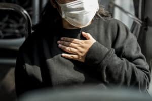 Sick woman in a mask having a difficulty breathing during coronavirus pandemic, co-occurring conditions massachusetts