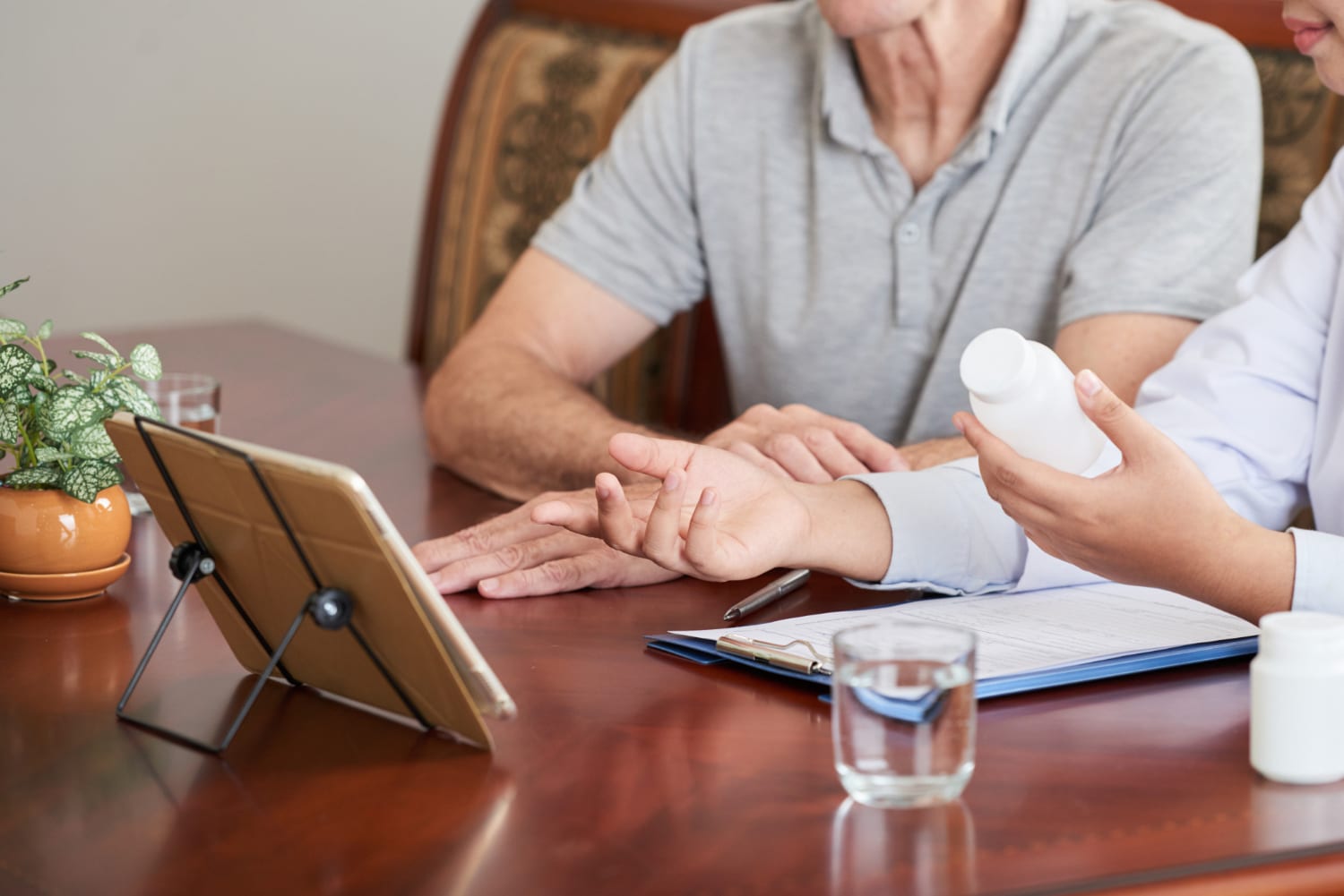 Female psychiatrist prescribing medication to male patient at home, providing therapy and medication support Broadway and A Street Boston