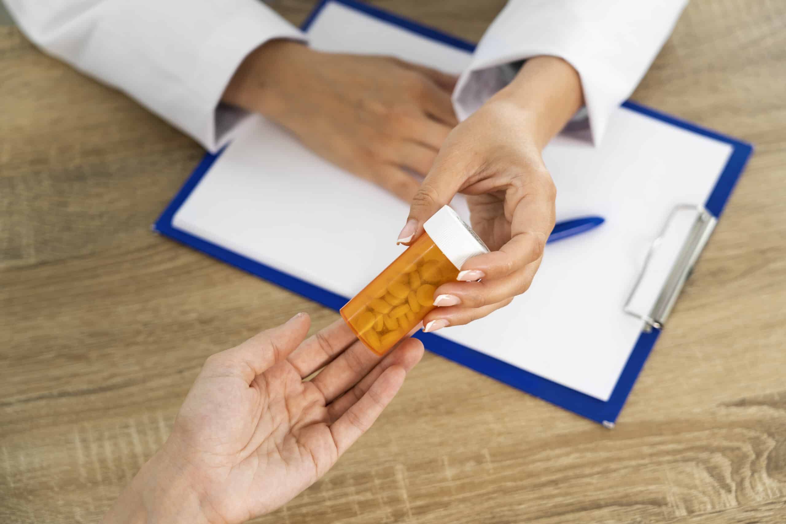 High-angle view of people holding pills during therapy and medication review near Seaport Boulevard and Fan Pier Boulevard Boston