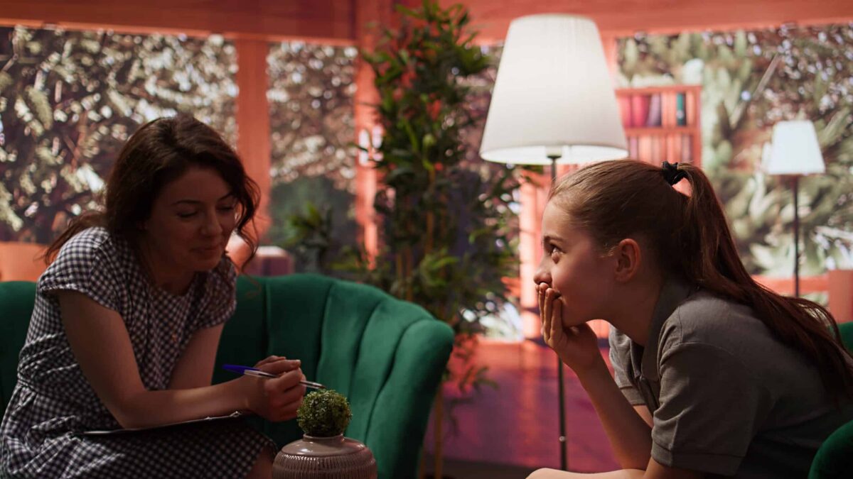 How to talk to teens about big emotions without calling it overreacting, teenage girl opening up about her mental health during a counseling session