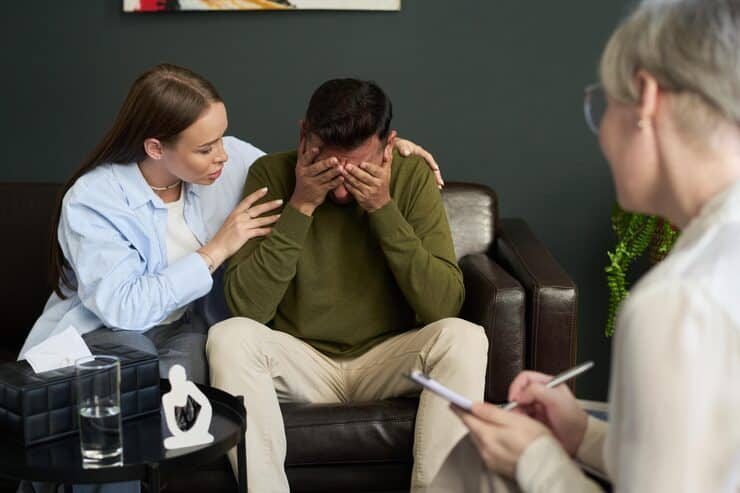 Young woman comforting a distressed man during a psychotherapy session in Massachusetts, highlighting psychotherapy for anxiety and depression