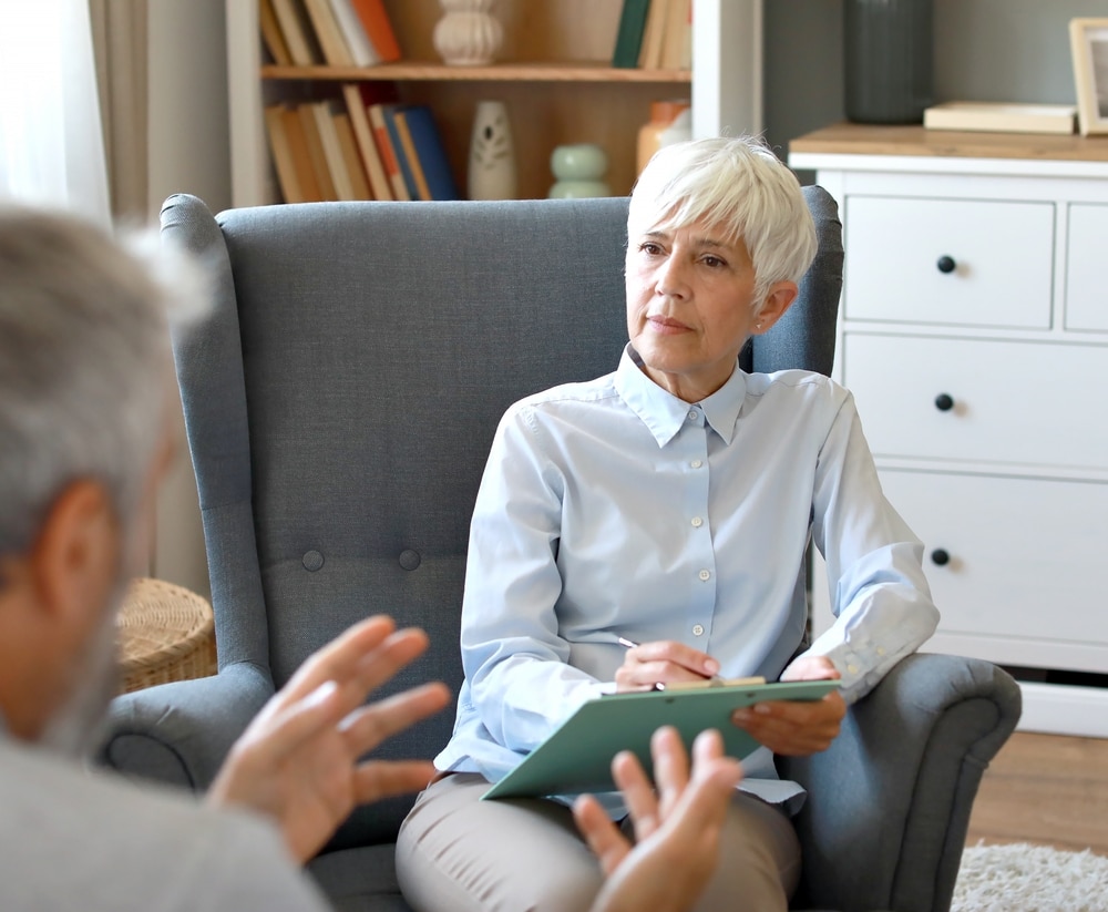 Mid aged woman psychiatrist during session with her patient in her office in clinic - psychiatry in massachusetts